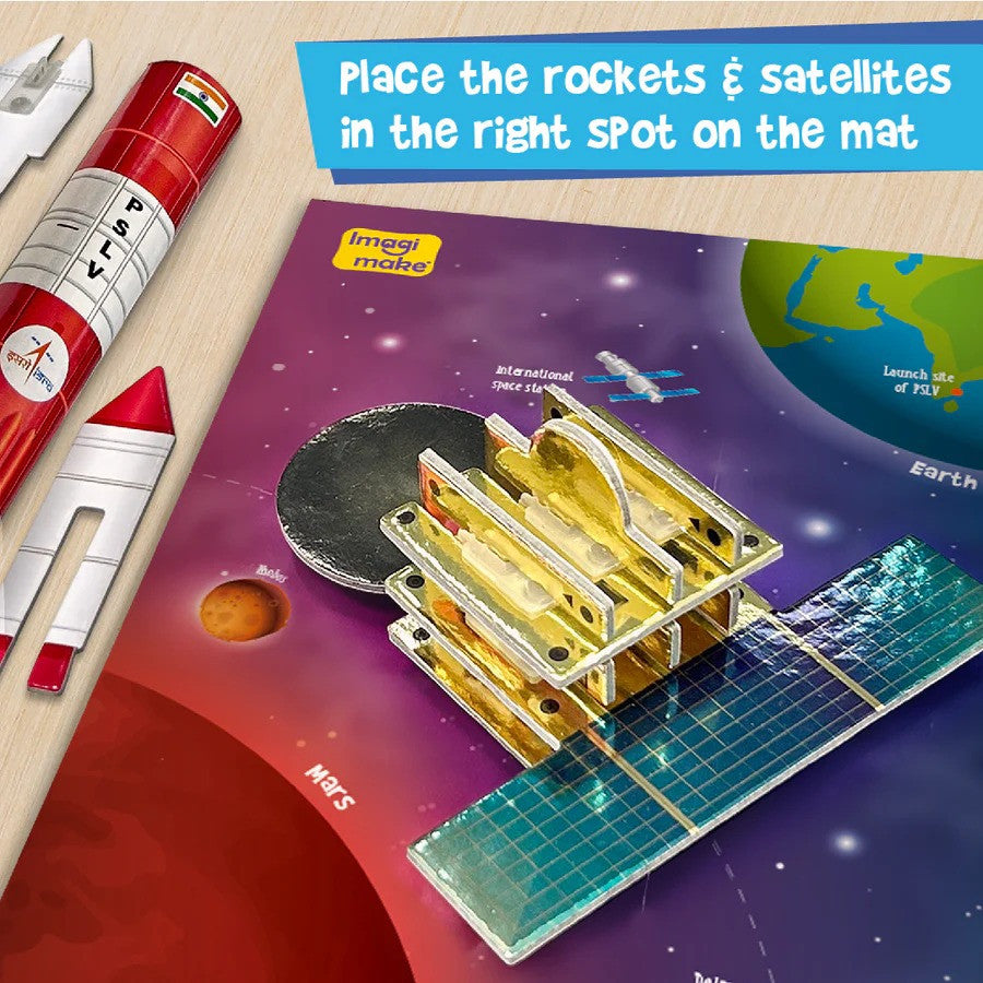 Space-themed educational mat with rockets and satellites on a wooden surface