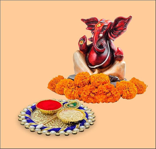 Decorative item with a red and gold elephant figure, marigold flowers, and a small tray on a beige background.