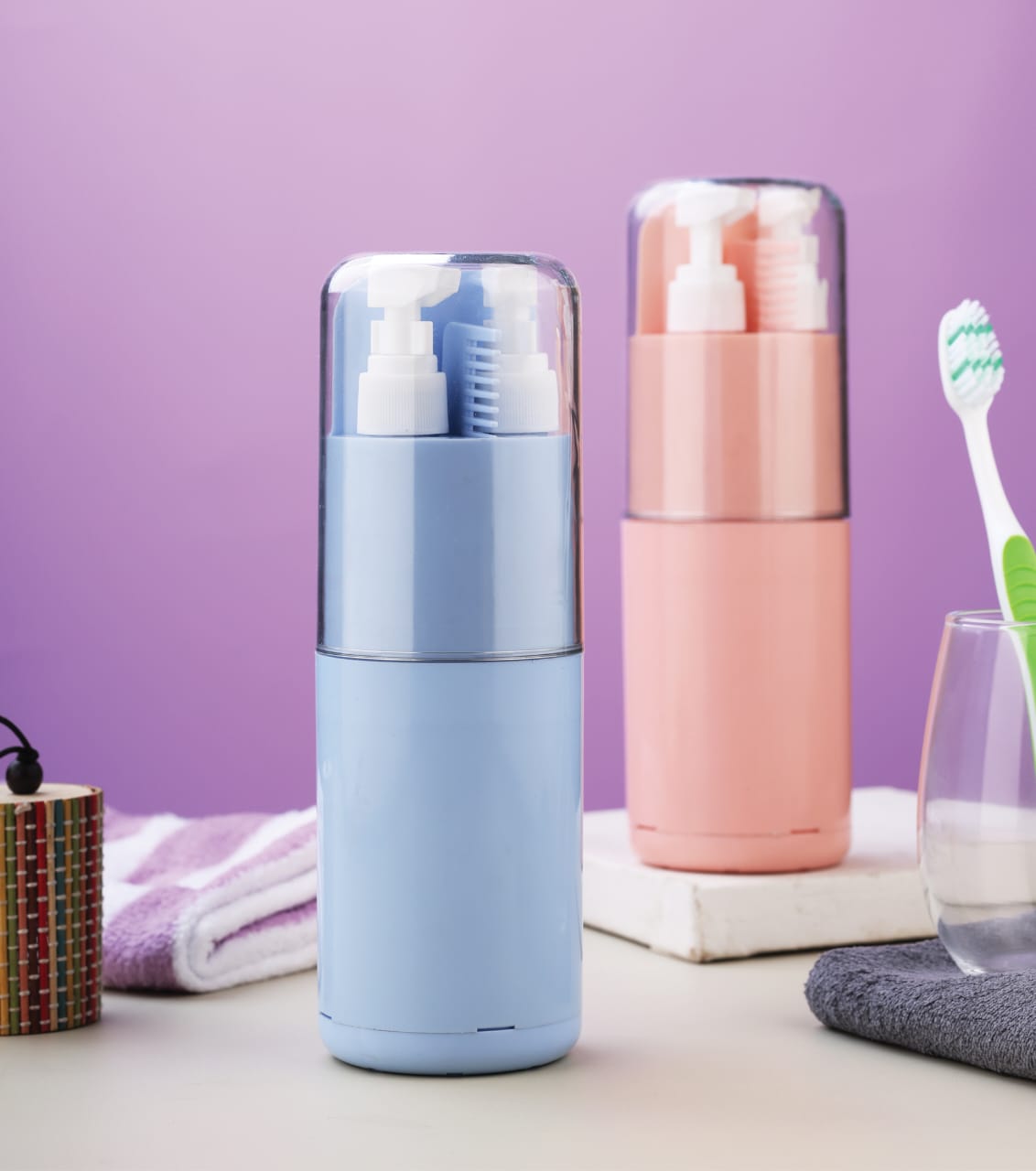 Two travel-sized bottles with toothbrushes on a table against a purple background