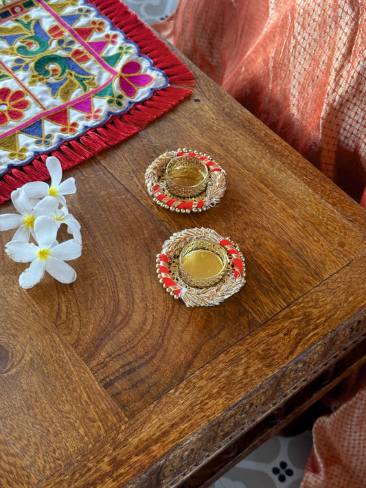 Decorative items on a wooden surface with a colorful fabric in the background