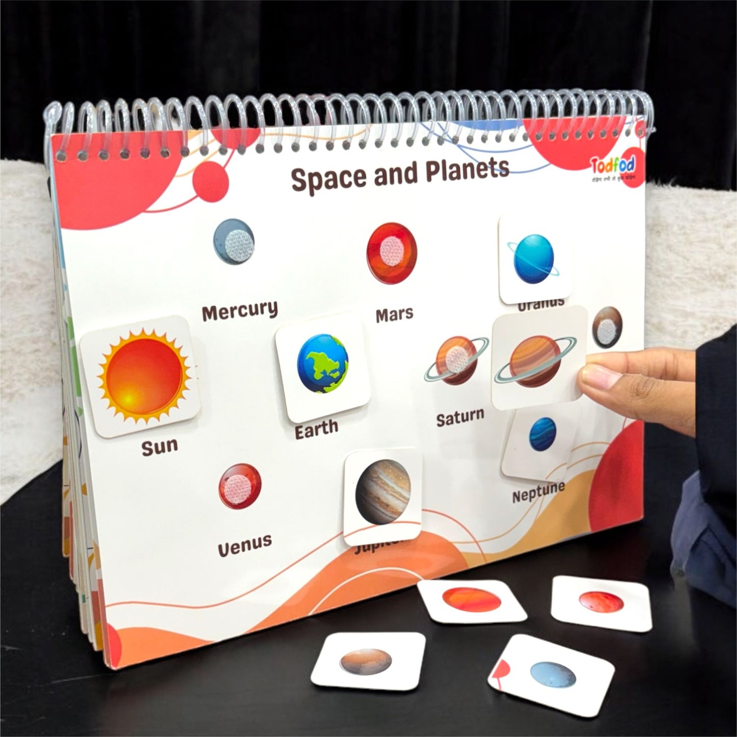 Educational book about space and planets with matching cards on a dark surface