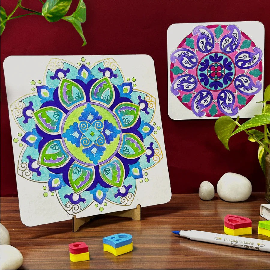 Colorful mandala design on a white board with markers and small objects on a wooden surface.