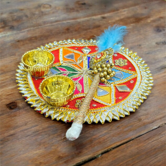 Decorative plate with gold cups and a blue feather on a wooden surface
