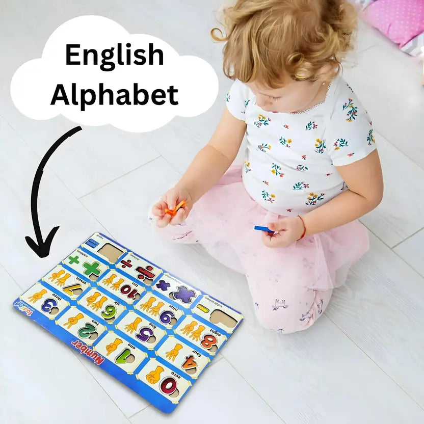Child playing with an English alphabet learning mat on a white floor.