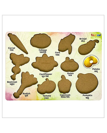 Todfod wooden vegetable puzzle board for kids showing vegetable shapes labeled in English and Hindi — carrot, cabbage, corn, brinjal, potato, beetroot, cauliflower, onion, radish, tomato, capsicum, and pumpkin.