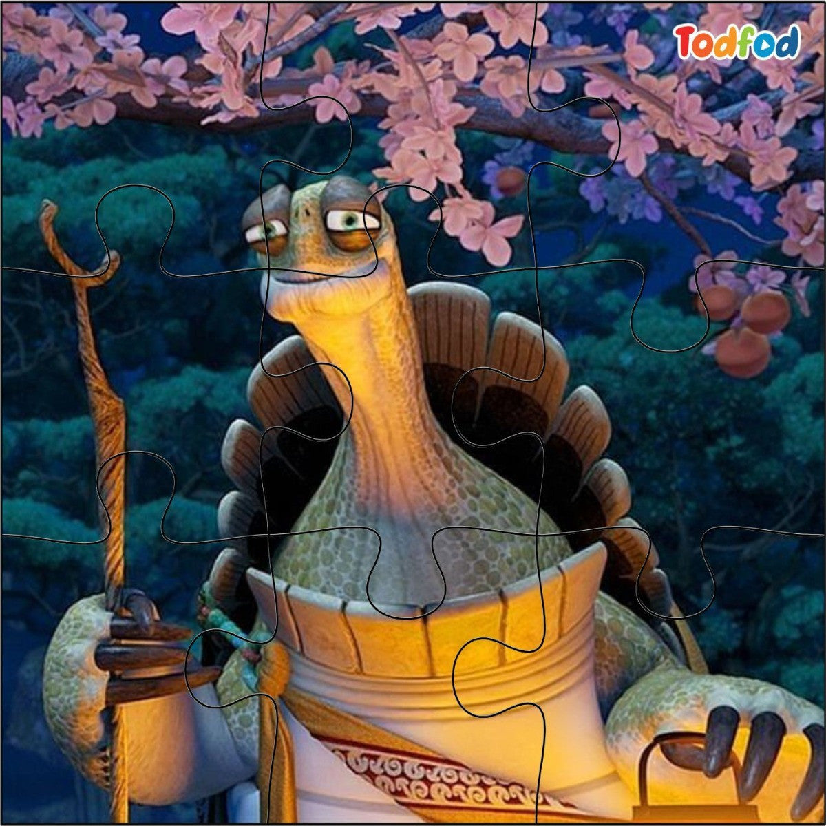 Jigsaw puzzle with a cartoon turtle character holding lanterns against a cherry blossom background, brand 'Todfod' visible.