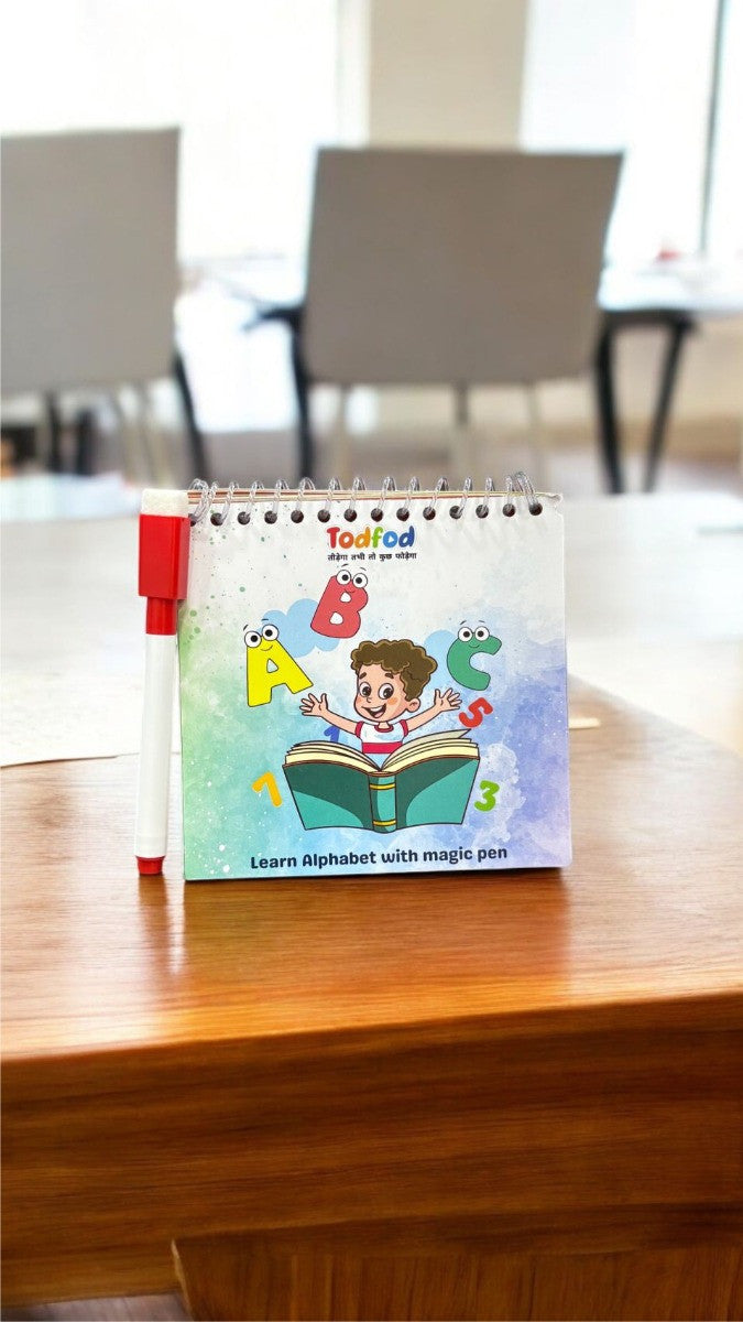 Children's educational book on a wooden table with chairs in the background