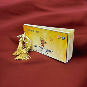 Small book with a gold tassel on a red fabric background