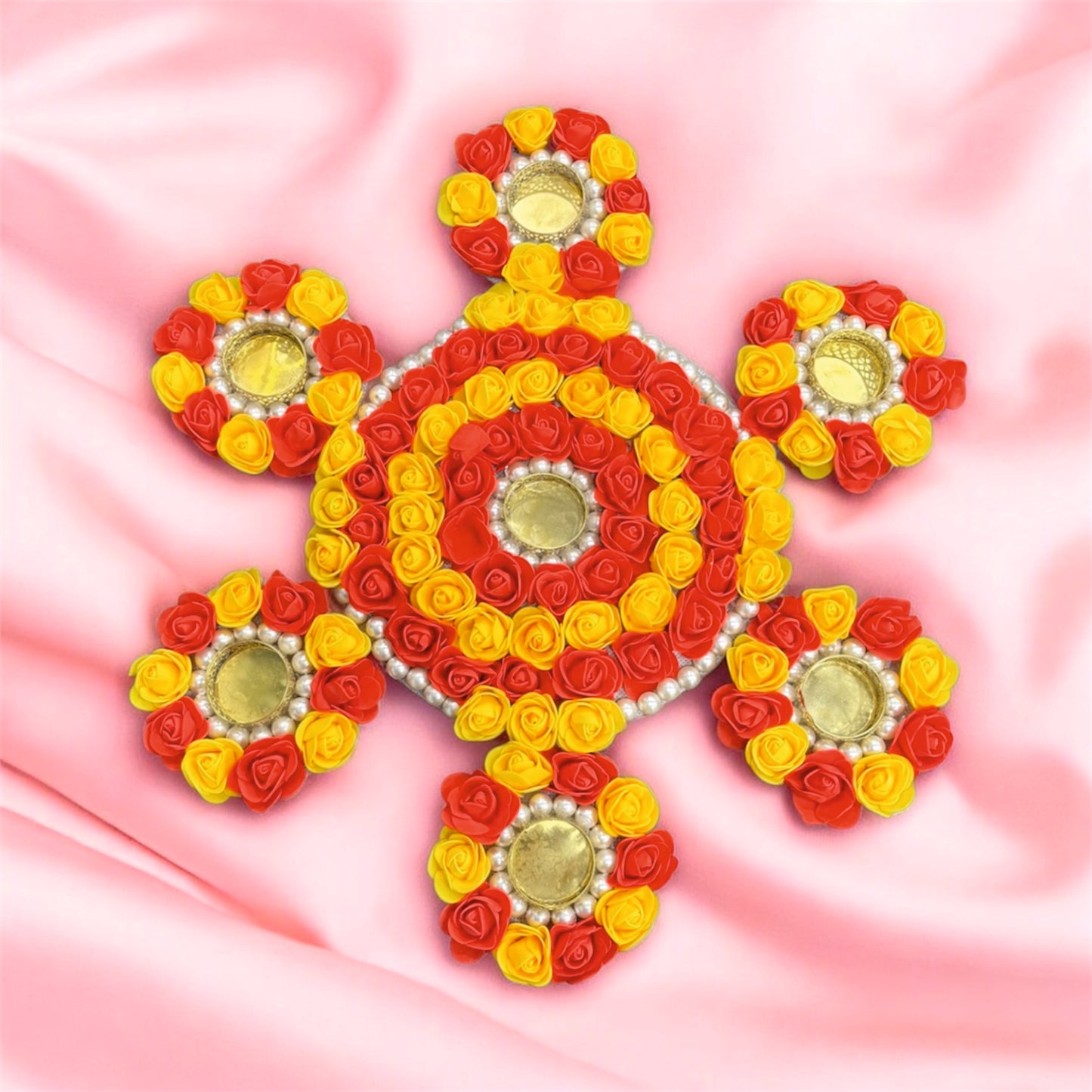 Decorative design made of red, yellow, and gold flowers on a pink background