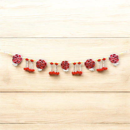 Decorative garland with red and white flowers on a wooden surface