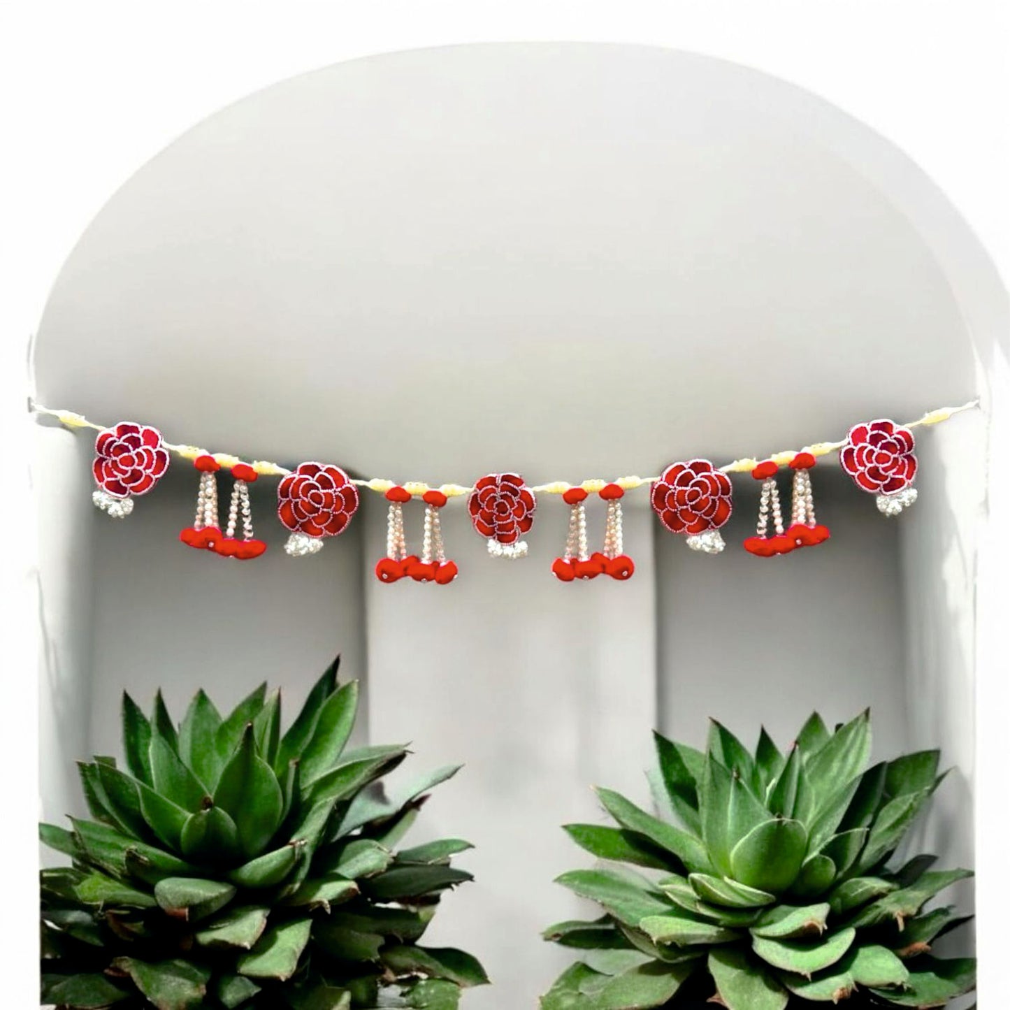 Decorative garland with red and pink flowers and small bells on a white background.