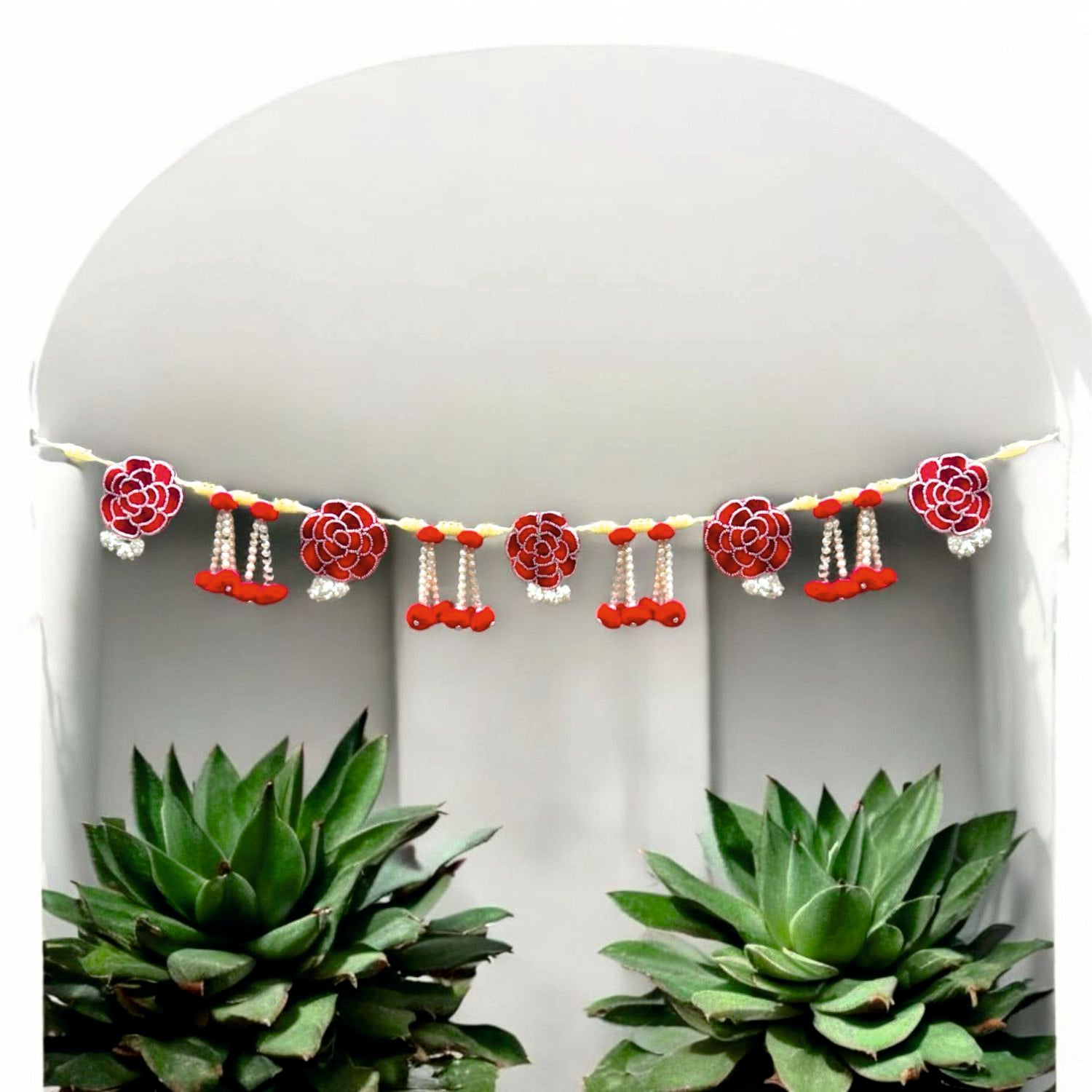 Decorative garland with red and pink flowers and small bells on a white background.