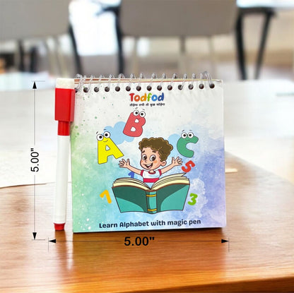 Small book with cartoon character and alphabet letters on a wooden surface