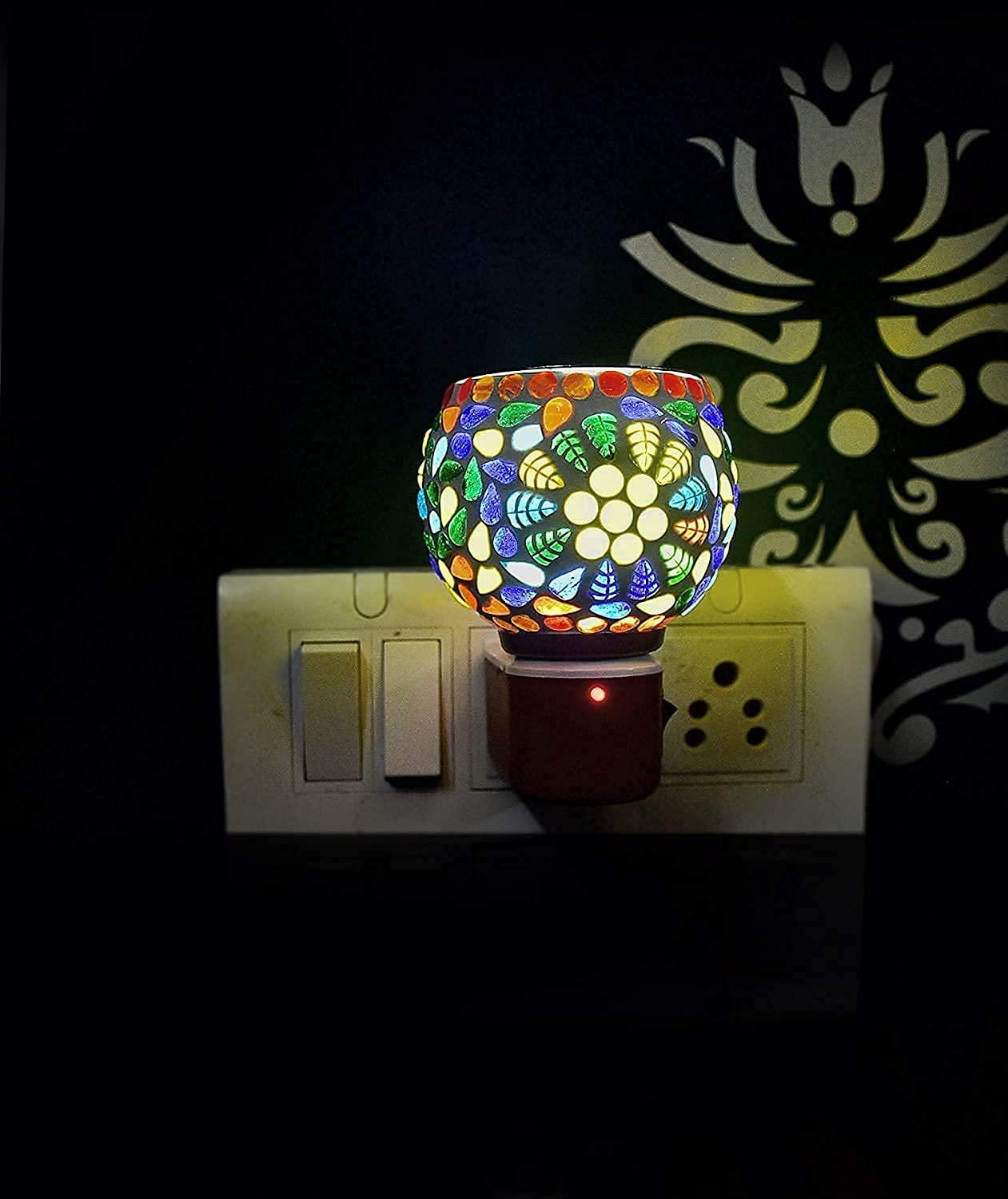 Colorful mosaic night light on a wall switch plate with a dark background
