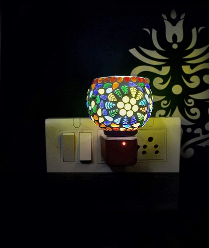 Colorful mosaic night light on a wall switch plate with a dark background