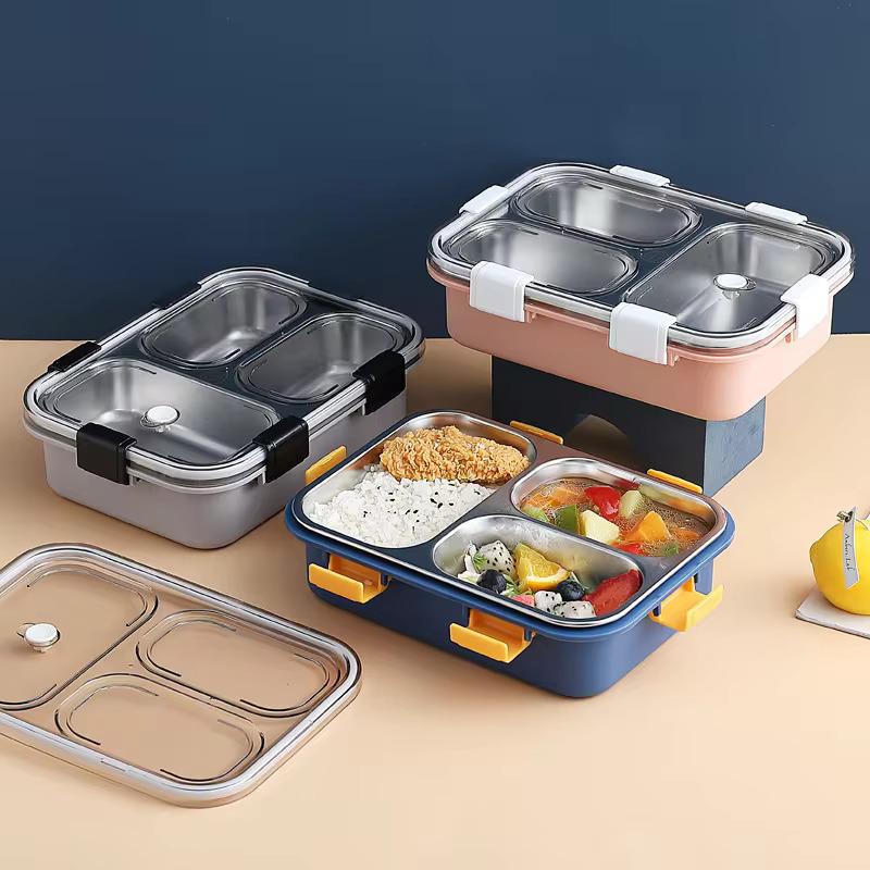 Set of four compartmentalized food containers with lids on a beige surface.