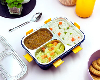 Meal container with compartments of food on a table with a spoon and drink.