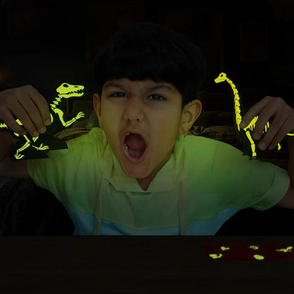 Child holding glow-in-the-dark dinosaur toys in a dark setting