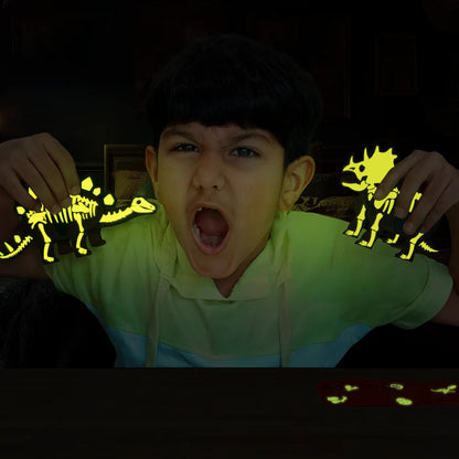 Child holding glow-in-the-dark dinosaur skeletons in a dark setting