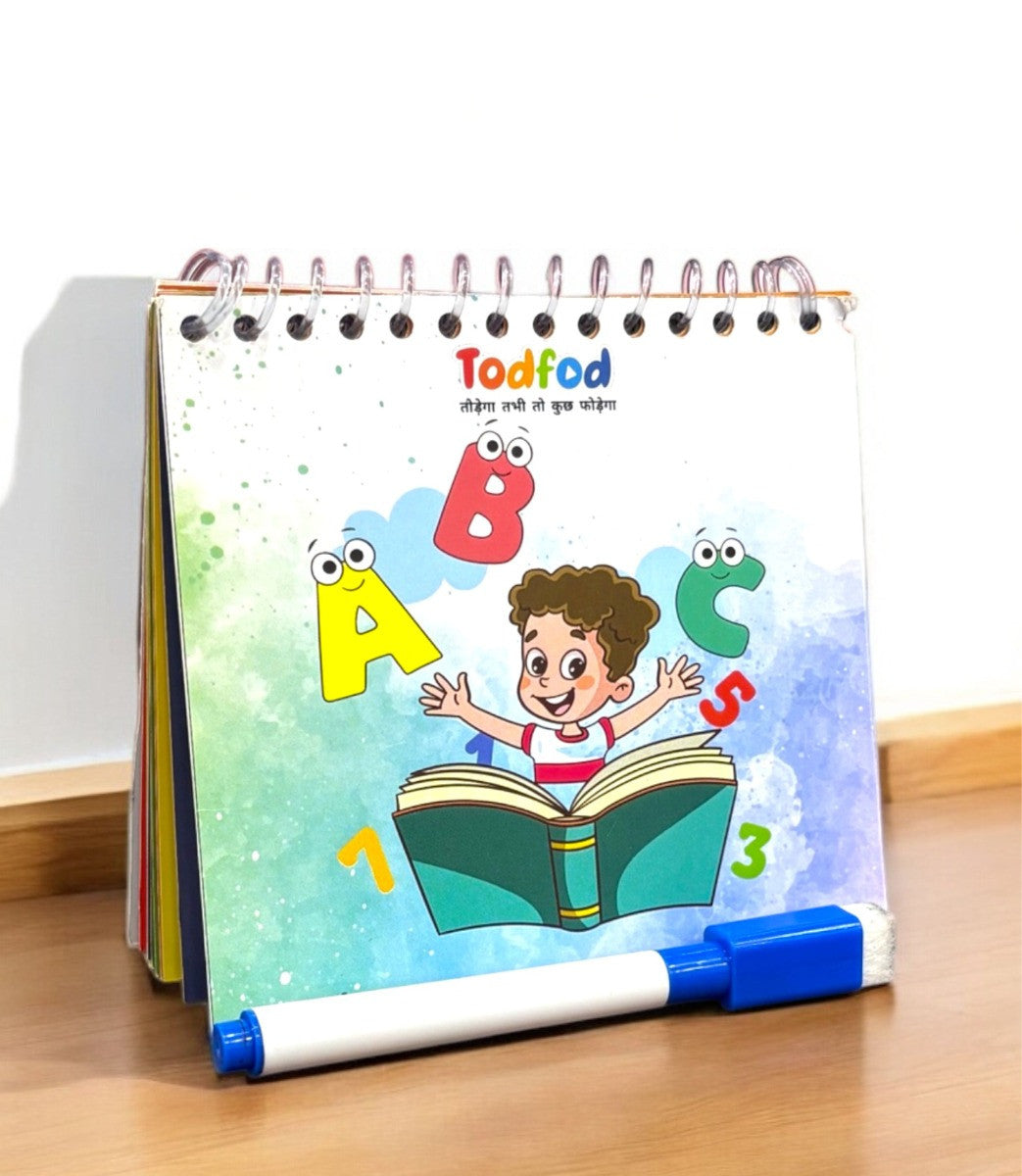 Children's educational book with colorful illustrations and a marker on a wooden surface
