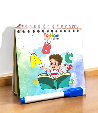 Children's educational book with colorful illustrations and a marker on a wooden surface