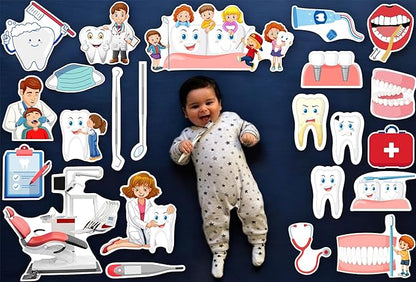 Baby lying on a dark blue surface surrounded by dental-themed illustrations and toys.