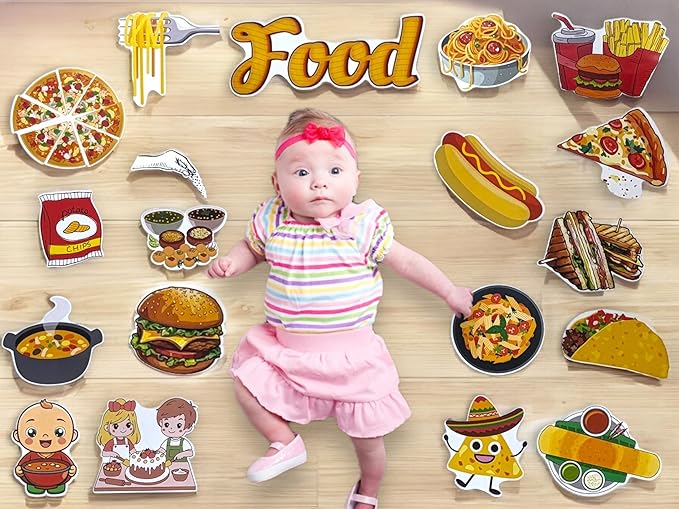 Baby surrounded by various food illustrations on a wooden surface