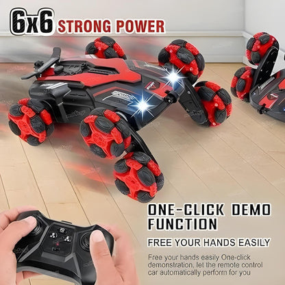 Toy car with red and black design on a wooden floor, controlled by a remote control.