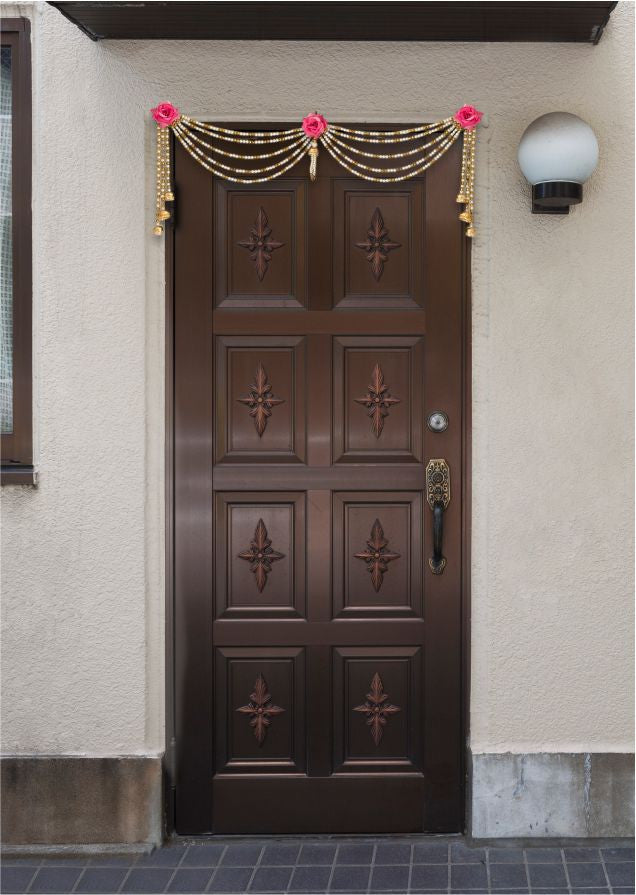 Decorative door with gold and pink decorations on a building exterior.