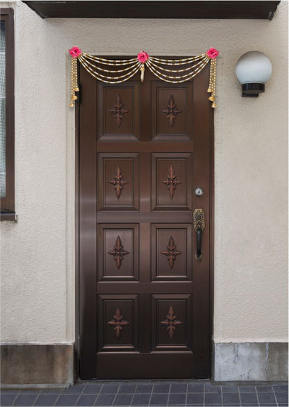 Decorative door with gold and pink decorations on a building exterior.