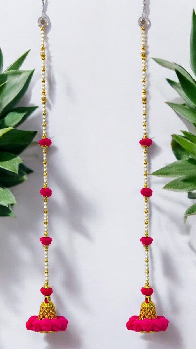 Pink and gold beaded earrings with leafy green plants in the background