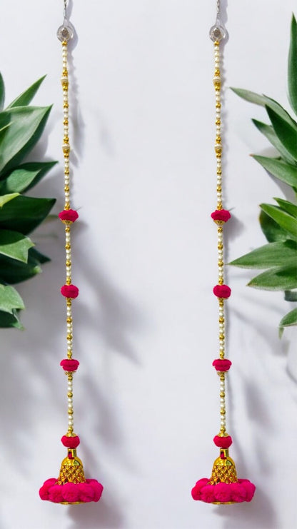 Pink and gold beaded earrings with leafy green plants in the background