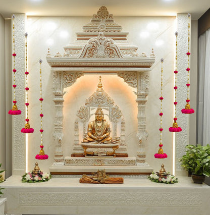 Decorative wall with Buddha statue and floral arrangements in a well-lit room.