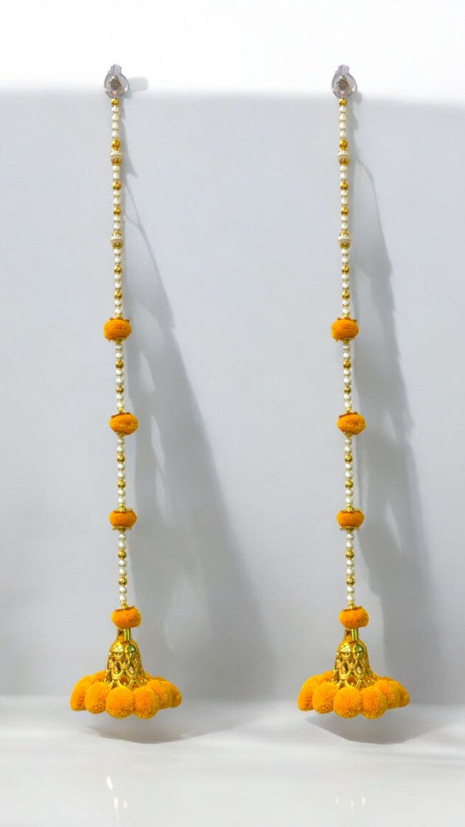 Pair of yellow floral earrings with gold accents on a white background