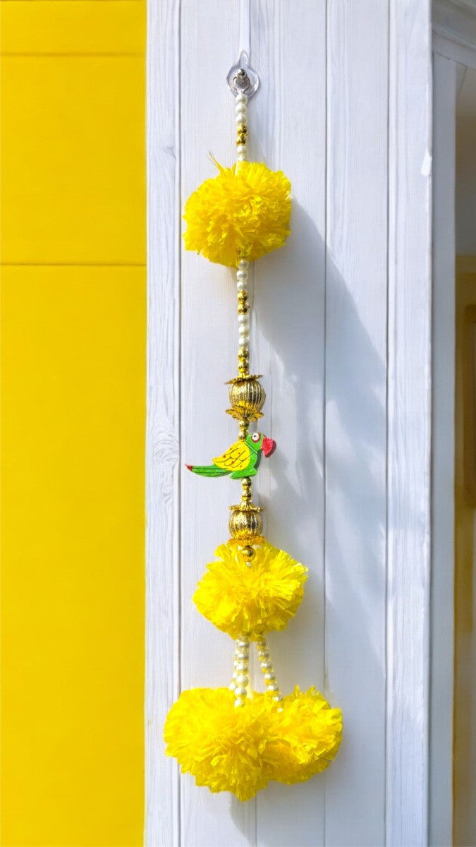 Decorative yellow pom-pom hanging on a white door with a yellow wall background