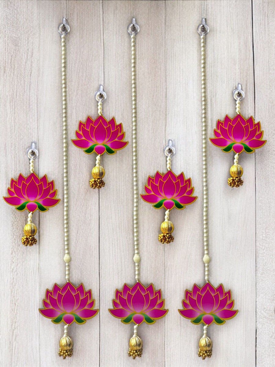 Set of pink lotus-shaped hanging decorations with gold accents on a wooden background