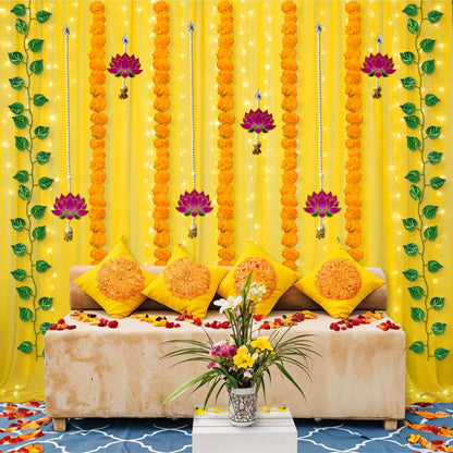 Decorative setup with yellow curtains, floral arrangements, and a sofa.