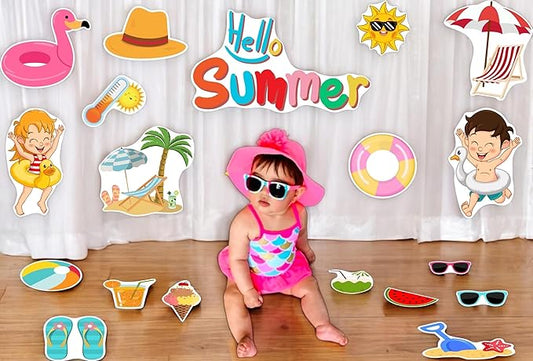 Child in summer-themed outfit with 'Hello Summer' text and beach-themed props on a wooden floor.